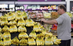 A customer shops for bananas at a store